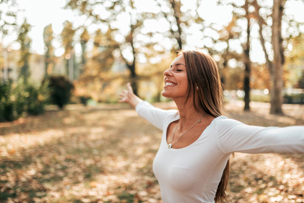 Happy woman enjoying the outdoors | Nervous System Reset | Reset Your Nervous System Naturally