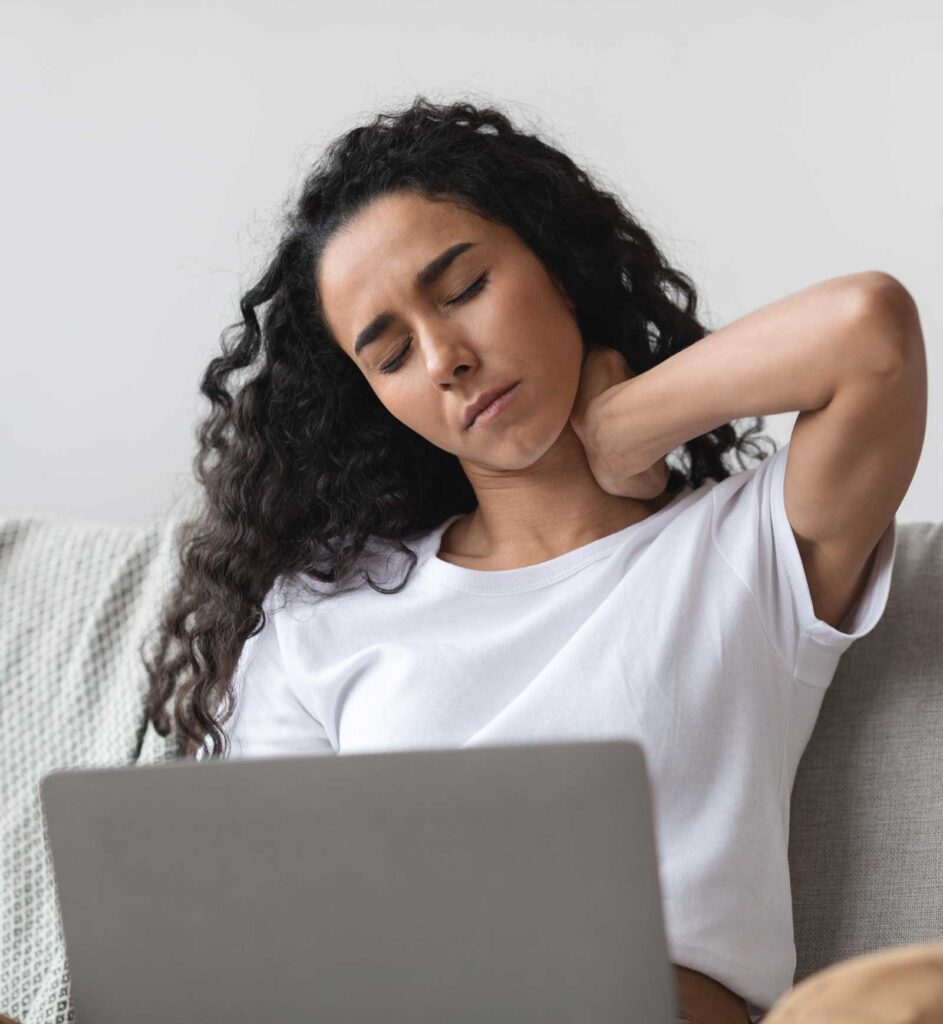 Stressed woman at a computer rubbing her neck | Acupuncture for Anxiety | Acupuncture for Depression, Stress & Trauma