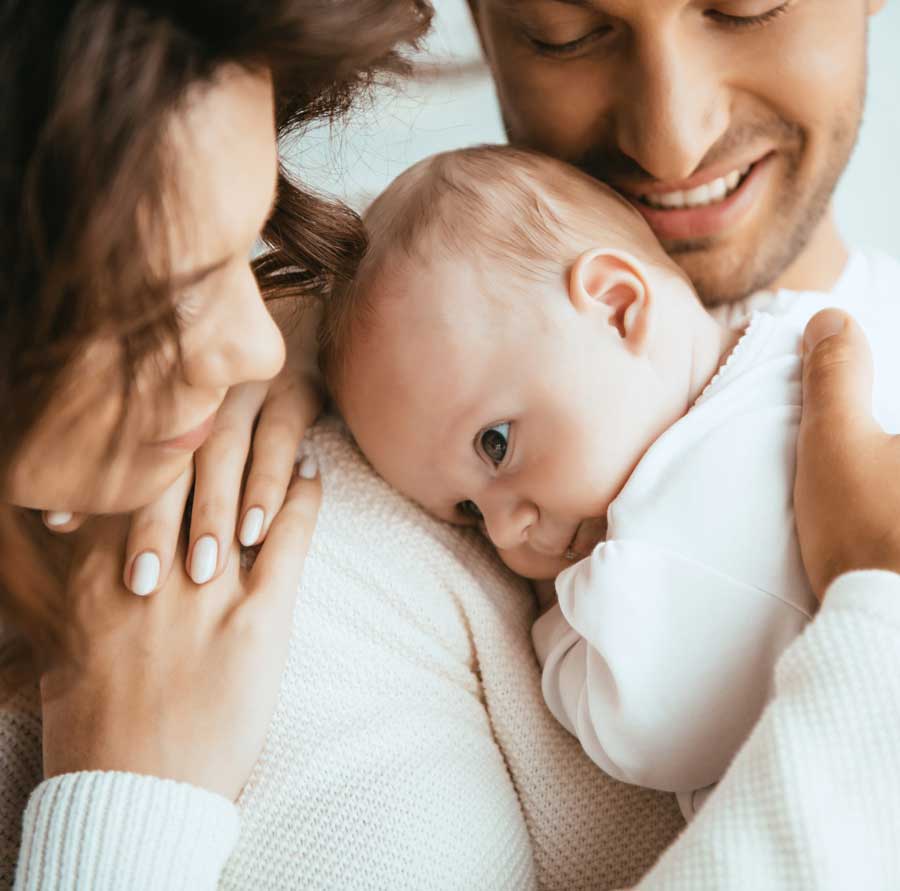 Couple holding newborn baby and smiling | Acupuncture for IVF & IUI in Boulder & Longmont