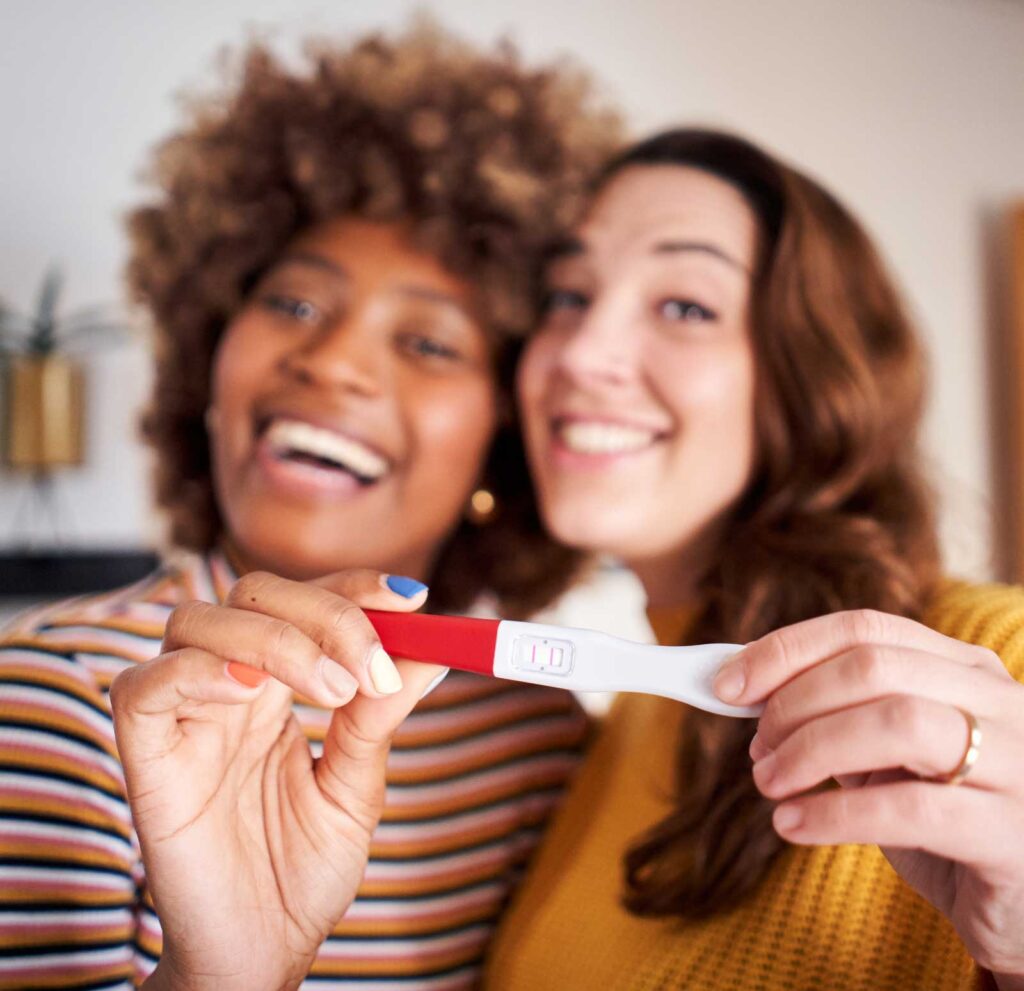 Lesbian couple with a positive pregnancy test | LGBTQ Acupuncture Boulder & Longmont | Well Woman Acupuncture | IVF Acupuncture | IUI Acupuncture in Boulder & Longmont | Well Woman