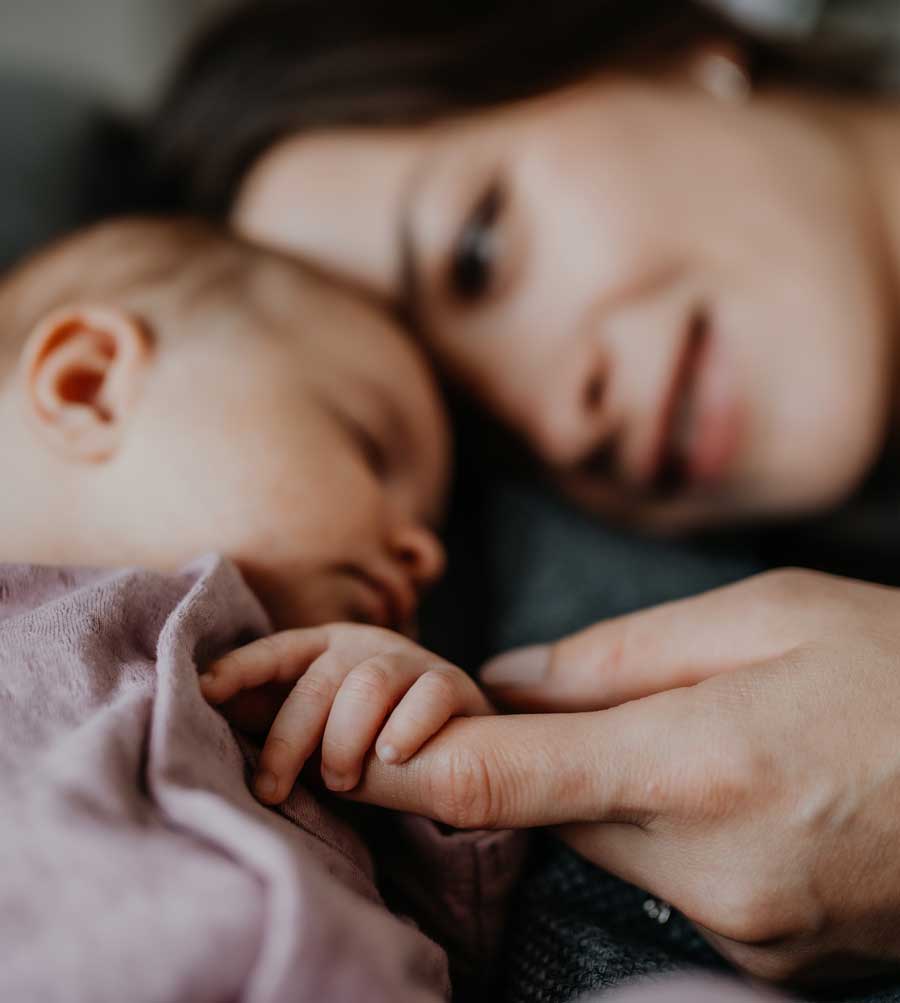 young mother admiring her small child holding the baby's hand and smiling | Acupuncture for Fertility | Boulder Acupuncture for Fertility | Longmont